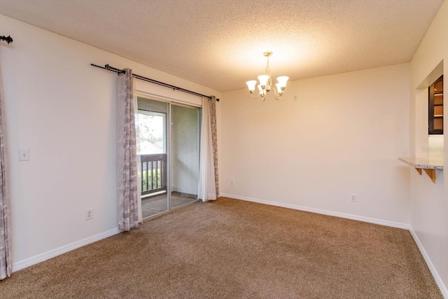 empty room with carpet floors, an inviting chandelier, baseboards, and a textured ceiling