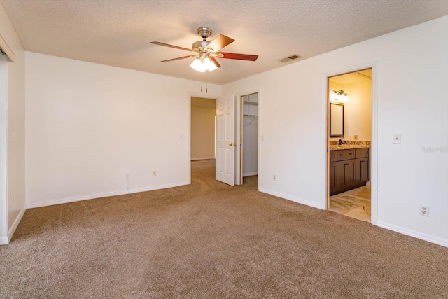 unfurnished bedroom featuring baseboards, visible vents, light carpet, and a textured ceiling