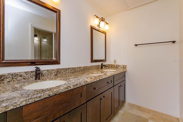 full bathroom featuring a sink, baseboards, and double vanity