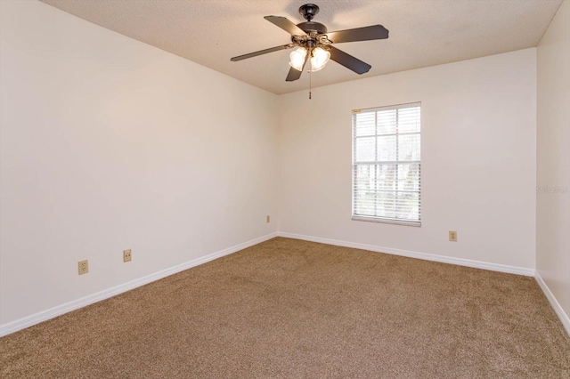 spare room with a ceiling fan, carpet flooring, a textured ceiling, and baseboards