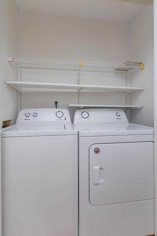 clothes washing area with laundry area and washer and clothes dryer