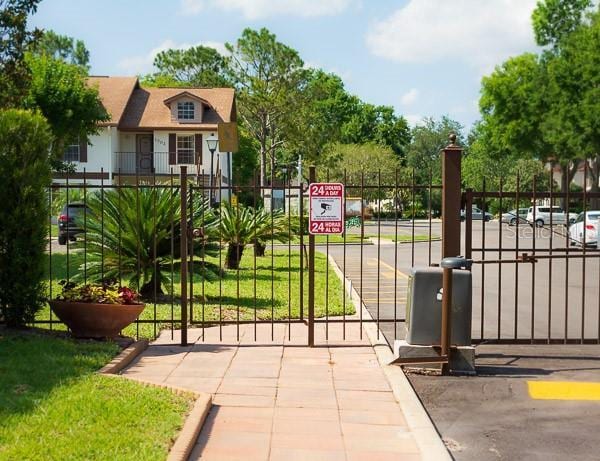 view of gate featuring fence and a lawn