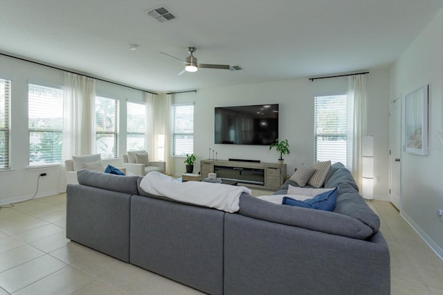 living area featuring light tile patterned floors, ceiling fan, a wealth of natural light, and visible vents