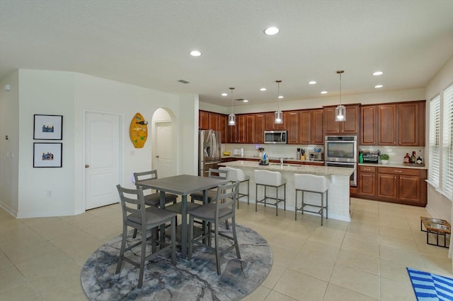 dining space featuring light tile patterned floors, visible vents, arched walkways, and recessed lighting