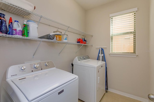 washroom featuring laundry area, baseboards, and washer and dryer