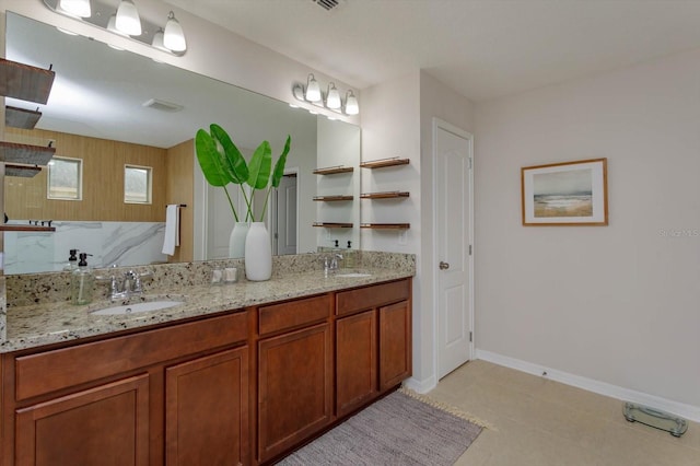 bathroom featuring double vanity, visible vents, baseboards, and a sink