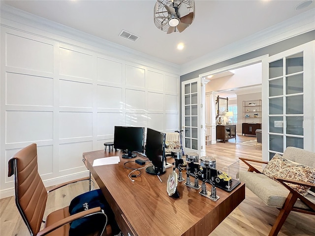 office area with light wood finished floors, visible vents, a ceiling fan, crown molding, and a decorative wall