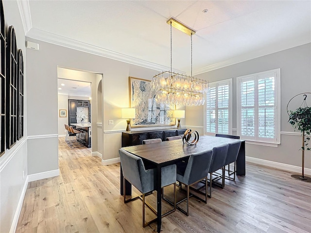 dining room with crown molding, light wood-style flooring, and baseboards