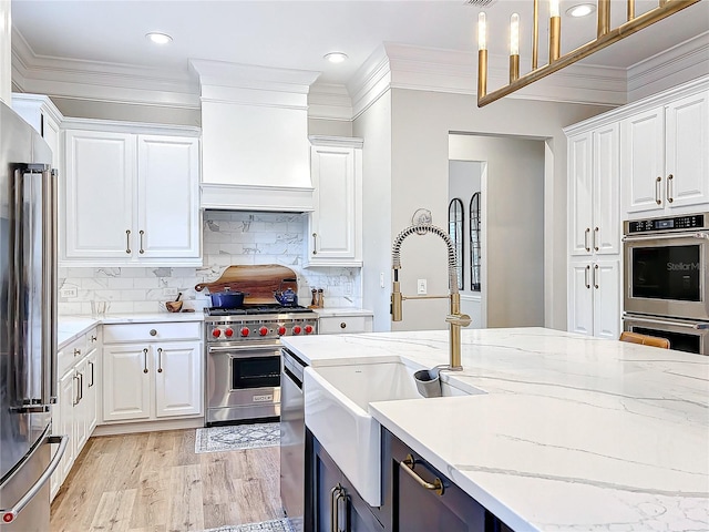 kitchen featuring white cabinetry, appliances with stainless steel finishes, backsplash, and a sink