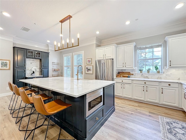 kitchen with appliances with stainless steel finishes, a spacious island, and white cabinets