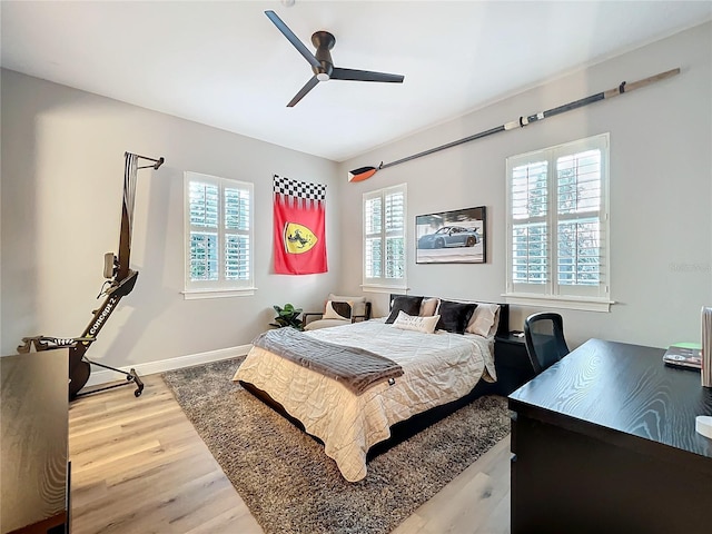 bedroom with a ceiling fan, baseboards, and wood finished floors