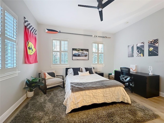 bedroom featuring wood finished floors, a ceiling fan, and baseboards