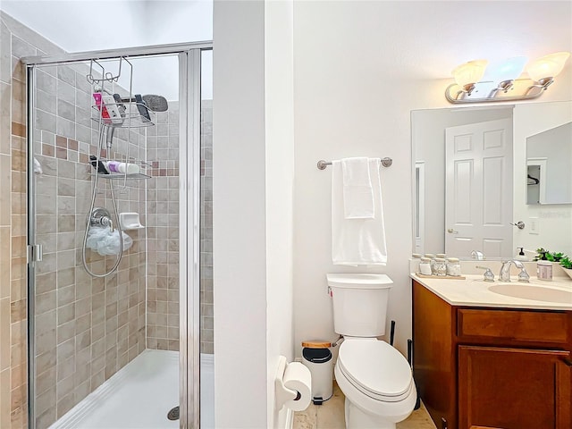 bathroom featuring toilet, a shower stall, and vanity