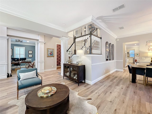 interior space featuring ornamental molding, visible vents, light wood-style floors, and ornate columns