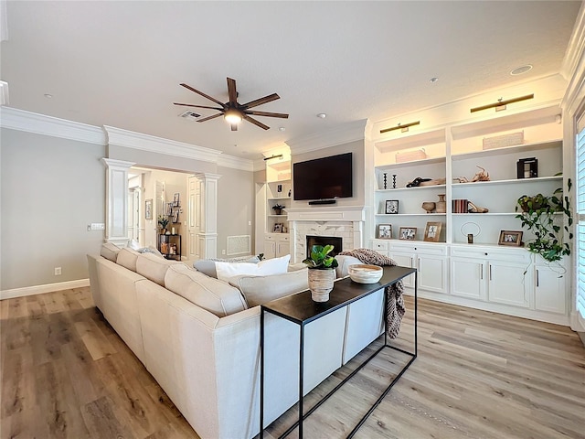 living room with ornamental molding, light wood-type flooring, and a fireplace