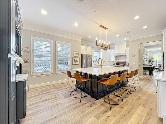 kitchen featuring crown molding, a breakfast bar, high end refrigerator, and tasteful backsplash