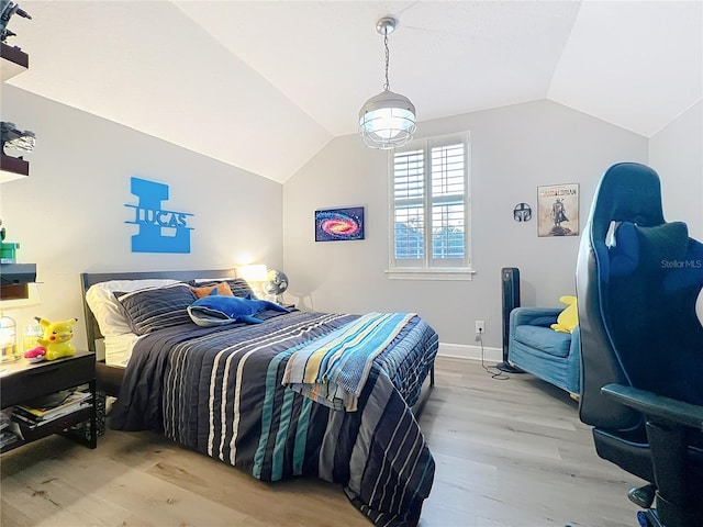 bedroom featuring lofted ceiling, wood finished floors, and baseboards