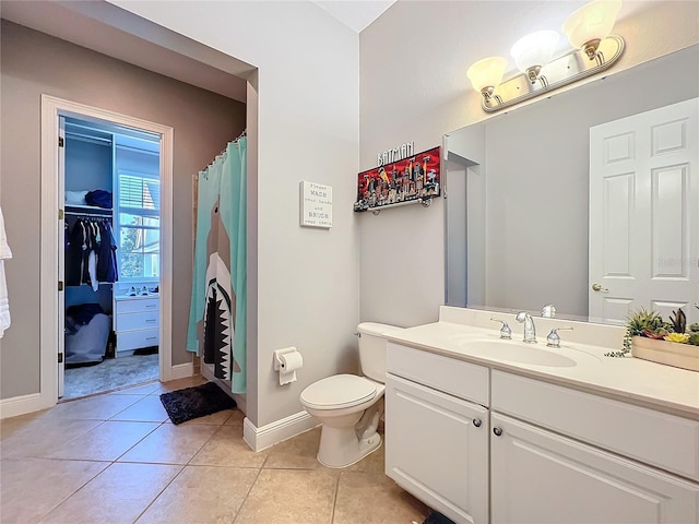 bathroom featuring curtained shower, toilet, vanity, baseboards, and tile patterned floors