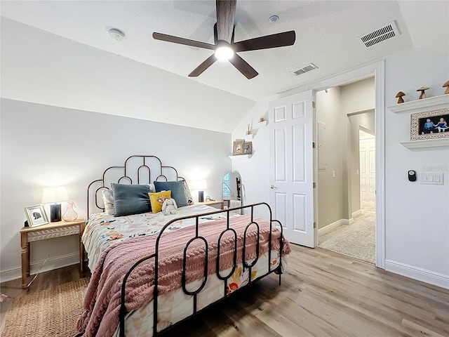 bedroom featuring visible vents, vaulted ceiling, and wood finished floors