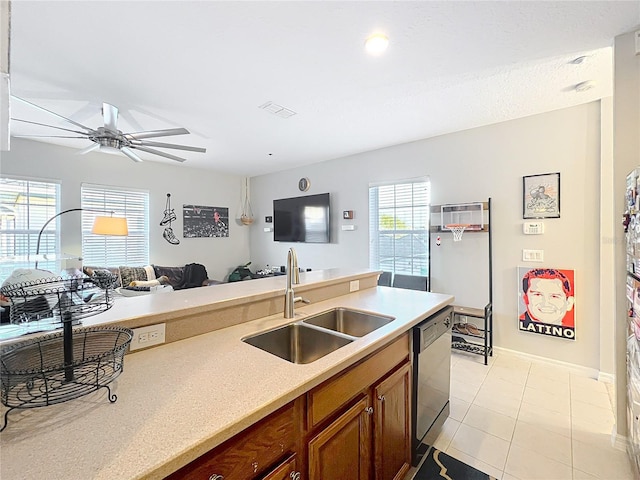 kitchen featuring light countertops, visible vents, stainless steel dishwasher, brown cabinetry, and a sink