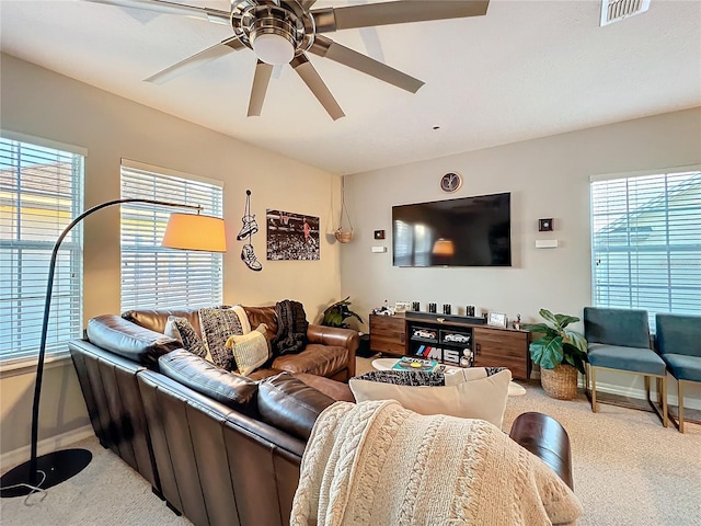 living room with visible vents, ceiling fan, a wealth of natural light, and light colored carpet