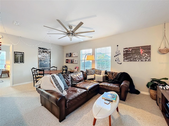 living room with carpet floors, baseboards, and a ceiling fan