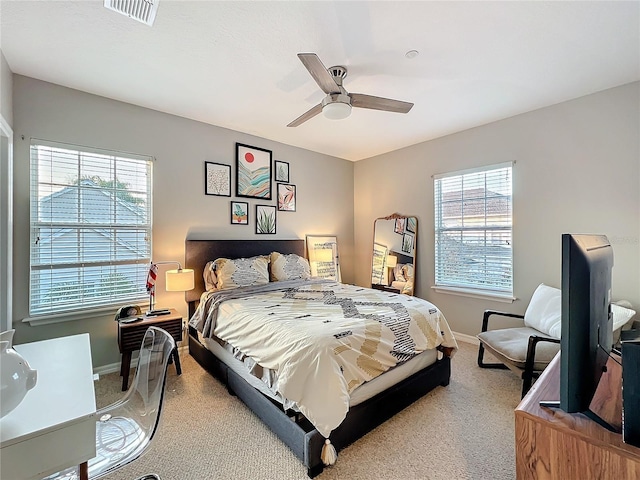 bedroom with light carpet, baseboards, visible vents, and ceiling fan