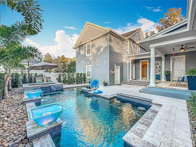 view of pool featuring a pool with connected hot tub, a patio area, fence, and ceiling fan