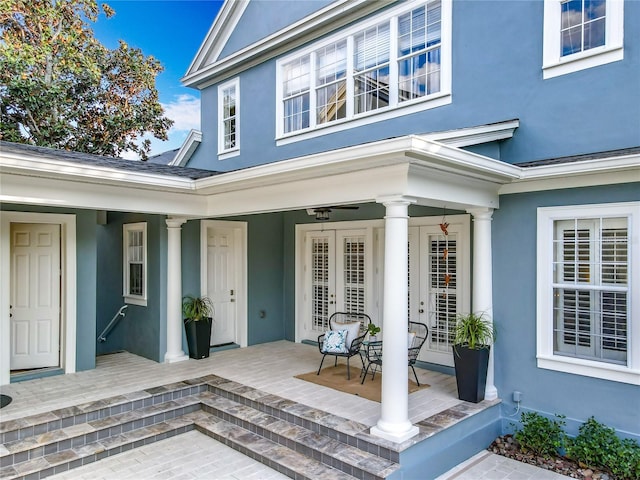 view of exterior entry with a porch and stucco siding