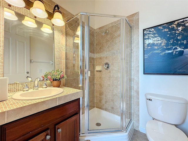 bathroom featuring a stall shower, vanity, and toilet