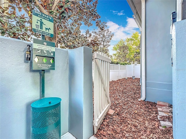 exterior details featuring fence, a gate, and stucco siding