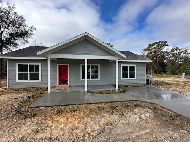 single story home featuring a shingled roof and covered porch