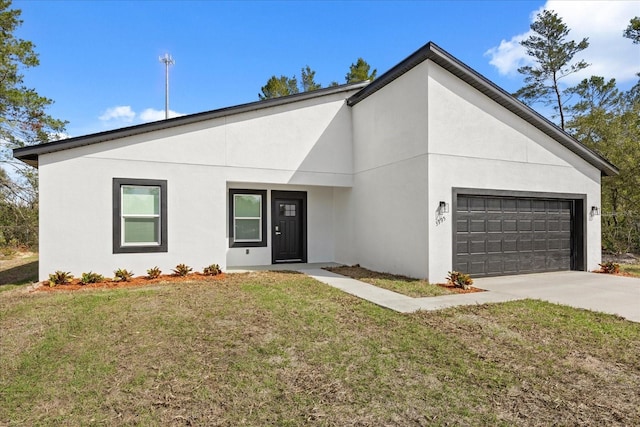 view of front of home with a front yard, driveway, an attached garage, and stucco siding