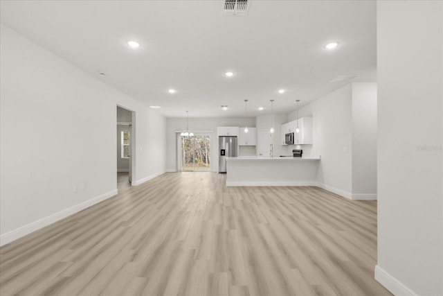 unfurnished living room featuring light wood finished floors, recessed lighting, visible vents, and baseboards