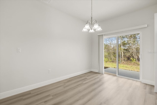 unfurnished dining area featuring light wood-style flooring, baseboards, and a chandelier