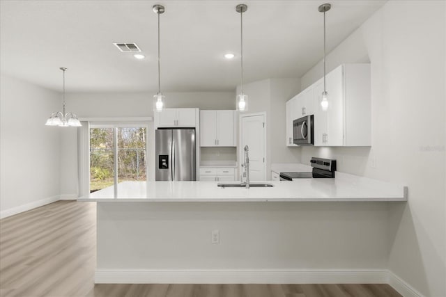 kitchen with white cabinets, appliances with stainless steel finishes, light countertops, and a sink