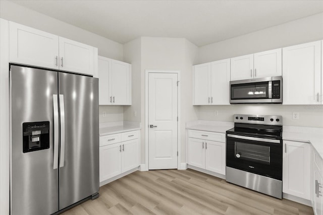 kitchen featuring stainless steel appliances, light countertops, light wood-style floors, and white cabinetry