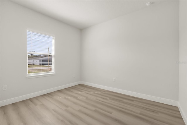 spare room featuring light wood-style flooring and baseboards