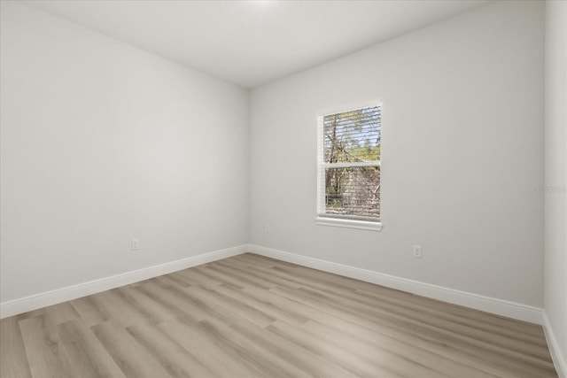 empty room with light wood-style floors and baseboards