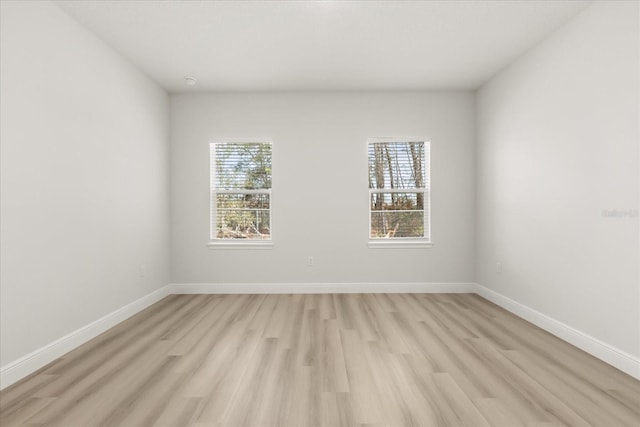 unfurnished room featuring light wood finished floors and baseboards