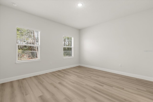 empty room with light wood-style flooring and baseboards