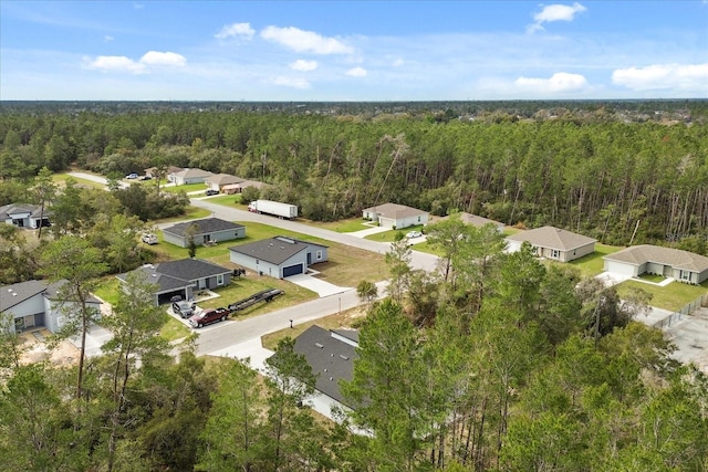 drone / aerial view featuring a forest view and a residential view