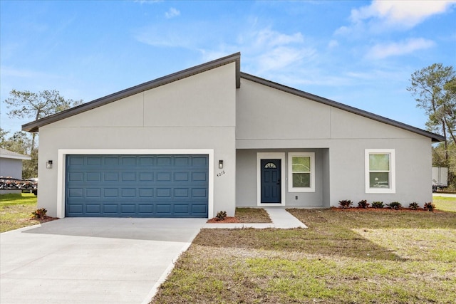 view of front of home with concrete driveway, stucco siding, an attached garage, and a front yard