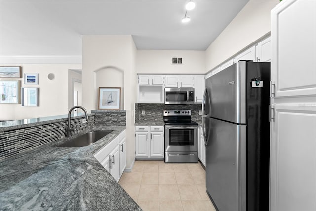 kitchen with visible vents, appliances with stainless steel finishes, white cabinets, a sink, and dark stone countertops