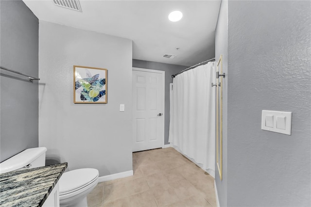 bathroom featuring baseboards, visible vents, toilet, and tile patterned floors