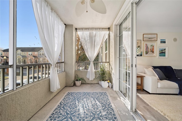 sunroom / solarium featuring a residential view and ceiling fan