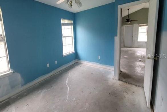 empty room featuring concrete flooring, baseboards, and a ceiling fan
