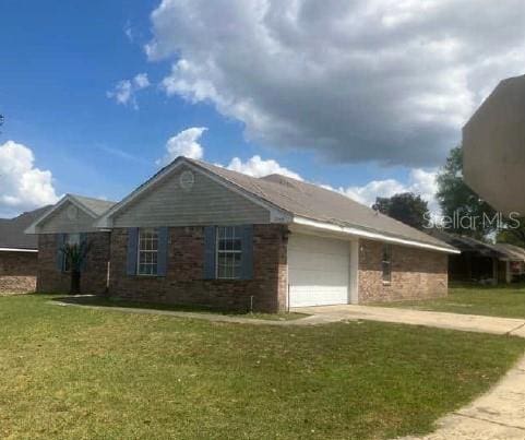 view of side of home featuring an attached garage, a yard, concrete driveway, and brick siding