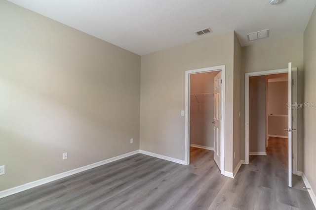 17437 Promenade Dr, Clermont, FL 34711 - unfurnished bedroom with wood finished floors, a walk in closet, and a closet