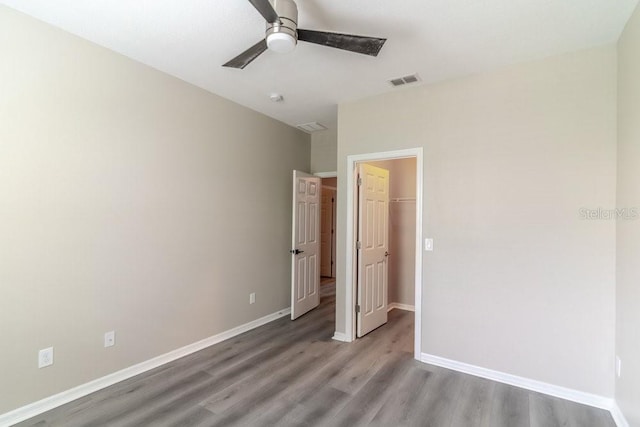 17437 Promenade Dr, Clermont, FL 34711 - unfurnished bedroom with wood finished floors, a walk in closet, ceiling fan, and a closet